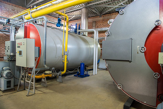 Modern industrial boiler room with compressor equipment and control panel.